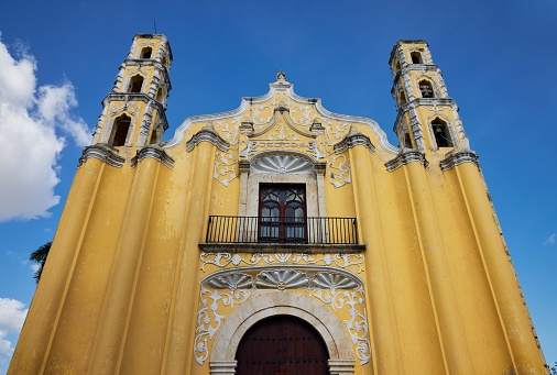 The Saint John Baptist Catholic church under a bright cloudy sky in Merida, Yucatan, Mexico