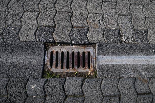 istock Closeup of a small rectangular manhole for rain water drainage with pattern of brick worm ground 1445653655