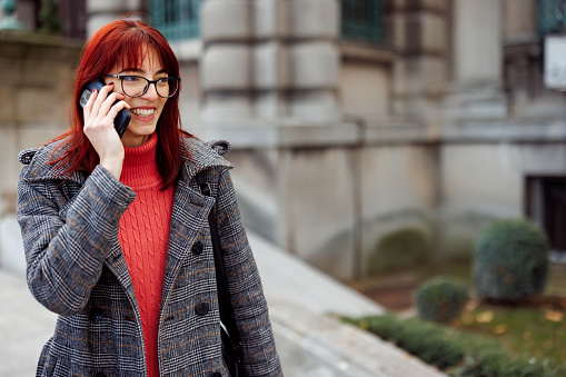 Portrait of happy young woman talking on the mobile phone outdoors