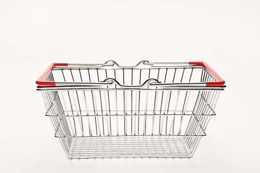 Empty silver colored metallic shopping basket on the white background