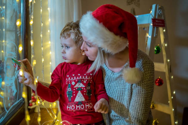 istock Young mother drawing with her boy on the window 1445672447