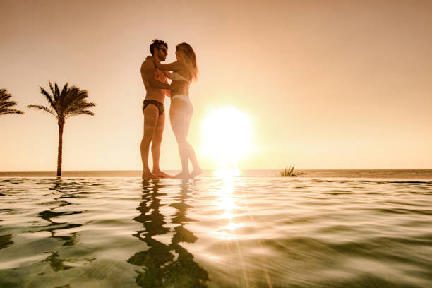 istock Affectionate couple at the edge of a pool in summer. 1445673552