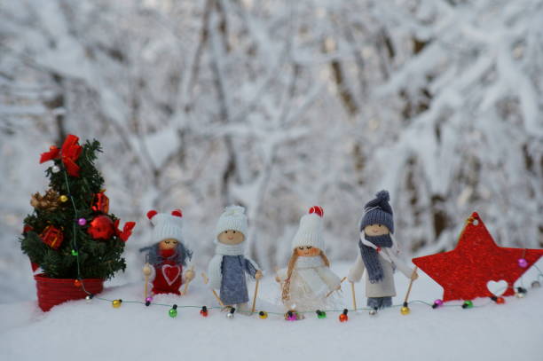 istock Toy angels on skis, decorated with a scarf and a hat. 1445673616