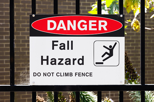 Danger sign on a black metal fence.