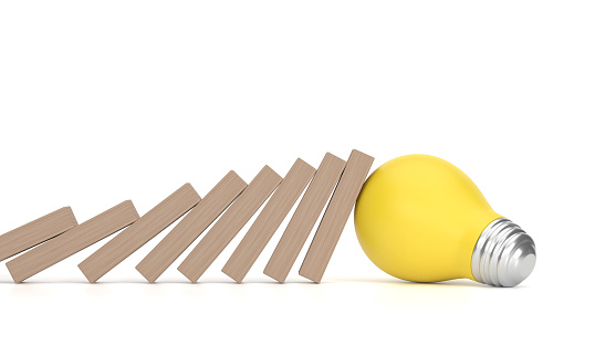 Light Bulb stopping wooden domino. Risk Management Concept.