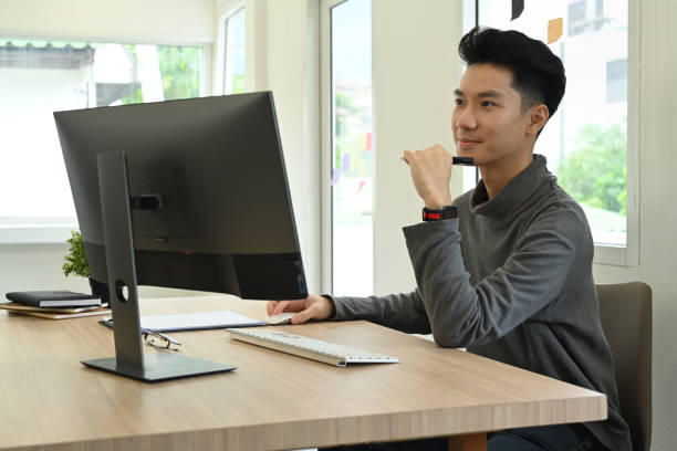 istock Young man video editor working with footage and post production montage in creative office studio. 1445673948