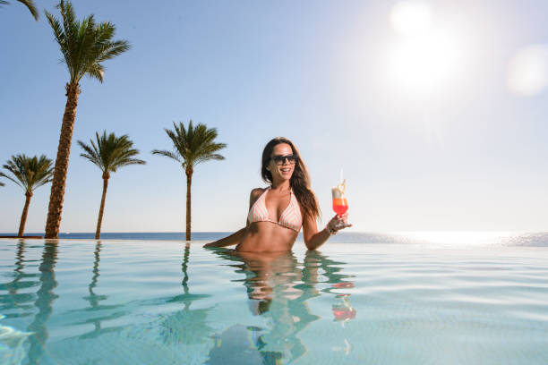 istock Happy woman spending a summer day in infinity pool. 1445674045