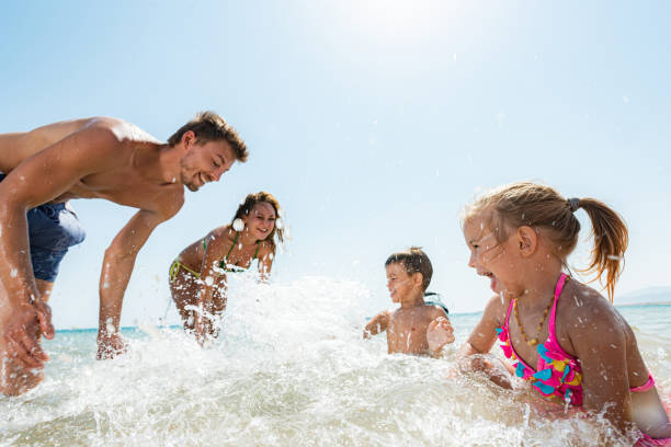 istock Playful family having fun while splashing in the sea. 1445674258