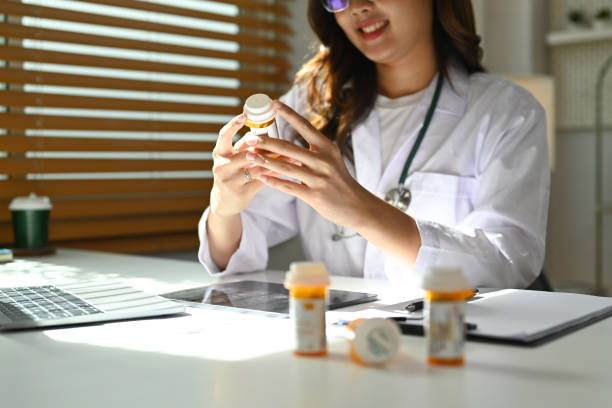 istock Doctor in white uniform using laptop computer while sitting in modern medical office. 1445675633
