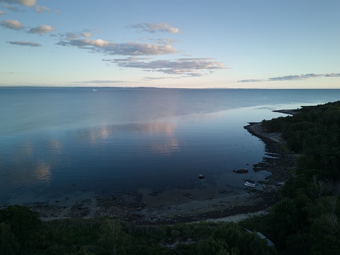 Aerial, drone image of a beach and coast of western Sweden in Görvik, Halmstad, Halland. Calm sea and bay with nice sky reflection in the water. Horizon and sky. No people. Idyllic landscape. Evening hours.