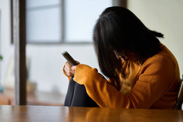 スマホを見て落ち込んでいる女性 - うつ病 ストックフォトと画像