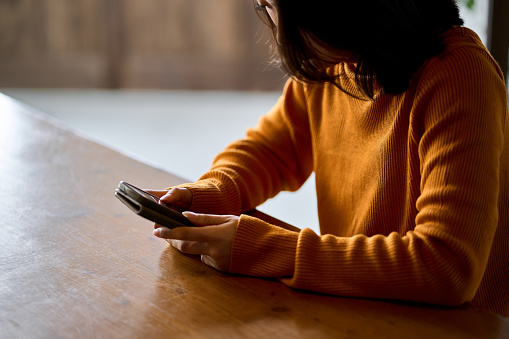 A woman who feels depressed looking at her smartphone