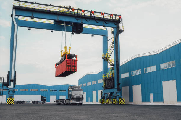 Gantry Crane Loading Freight Containers At Distribution Warehouse Gantry crane loads freight containers to trucks at a distribution warehouse. gantry crane stock pictures, royalty-free photos & images
