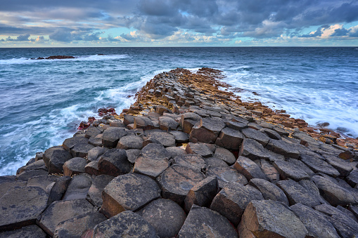 atlantic coastline with Volcanic hexagonal basalt columns of Giant`s Causeway at sunset in Northern Ireland