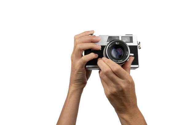 istock Female hands holding an old vintage camera on white background 1445681174