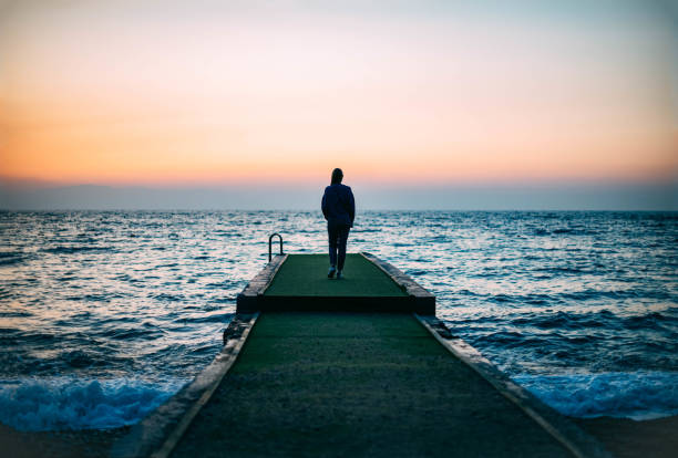 istock Young Woman Walking on the Beach at Sunset 1445688269