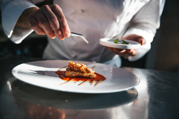 Chef preparing a gilthead bream dish in a luxury restaurant stock photo