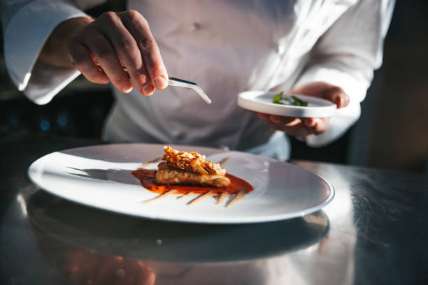 Chef preparing a gilthead bream dish in a luxury restaurant Chef preparing a gilthead bream dish in a luxury restaurant, close up view. tropical fish closeup stock pictures, royalty-free photos & images