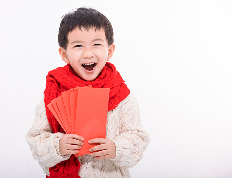 Excited Asian boy showing and holding many of red envelope . Happy Chinese New Year Concept.