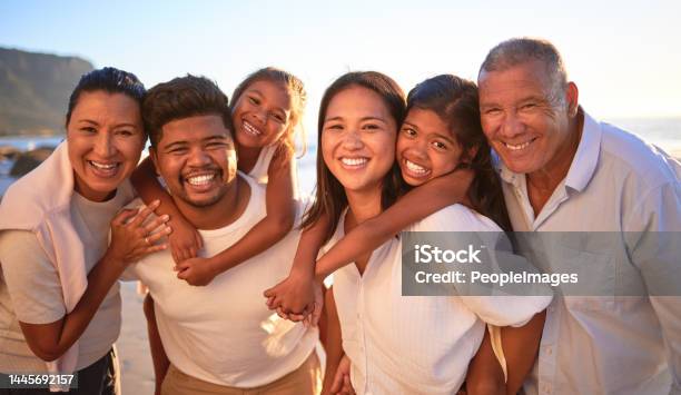 Portrait Of Happy Family With Children Smile And Hug Together On A Sunset Beach Adorable Little Kids Bonding With Mother Father Grandmother And Grandfather Outdoor On Summer Vacation At The Ocean Stock Photo - Download Image Now