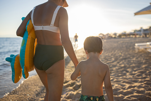 Mother and son walking together on the beach