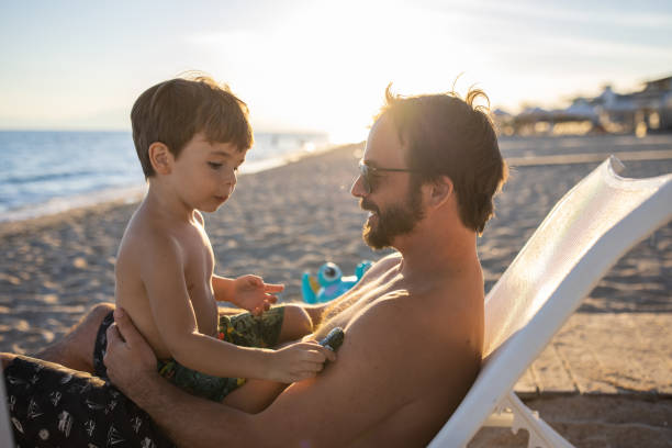 istock Father and son relaxing together on the beach 1445693215
