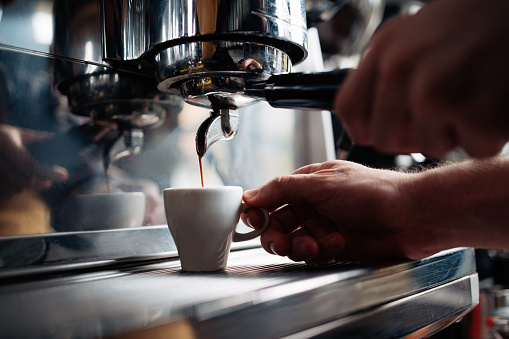 Un hombre anónimo haciendo espresso en una cafetería photo