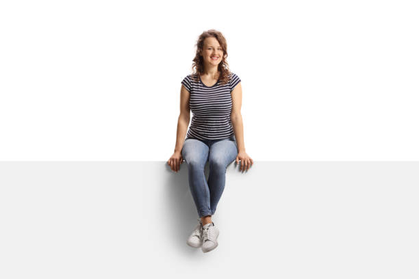 istock Casual young female sitting on a blank panel 1445694095