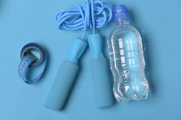 istock Skipping rope in cyan color on blue background, top view. 1445694176
