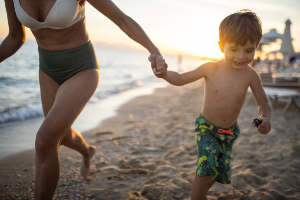 istock Mother and son running on the beach together 1445694602