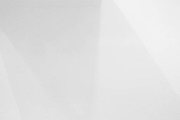 istock White Concrete Wall with Light Beam and Shadow on the Surface. 1445694708
