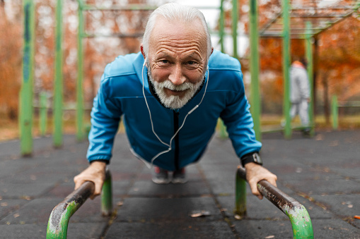 Senior man in sports clothing working exercise in the park