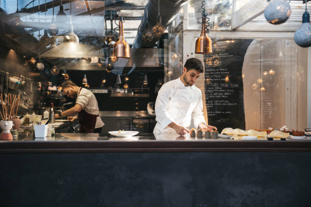 istock Young chef plating and finalizing food in a fine dining luxury restaurant 1445694799
