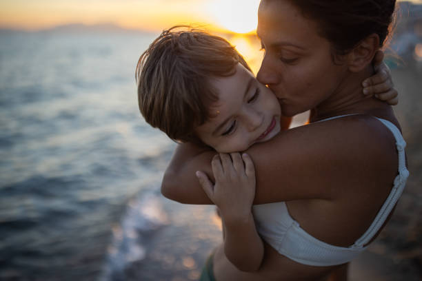 istock Mother kissing her son on the beach 1445695434
