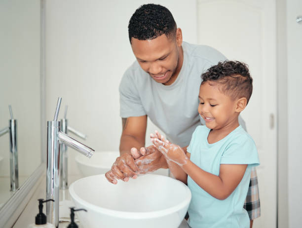 sapone, padre e bambino che puliscono le mani per l'igiene, il benessere e la routine mattutina positiva in uno stile di vita sano. felice, sorridere e papà si diverte a lavarsi le dita con il bambino, il ragazzo o il figlio in bagno - lavarsi le mani foto e immagini stock