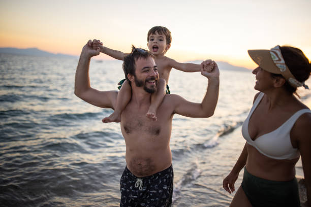 istock Father carrying his son on his shoulders on a beach 1445697484