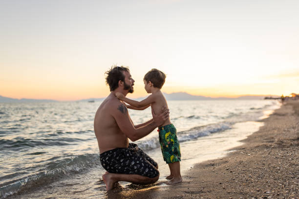Father and son embracing on the beach