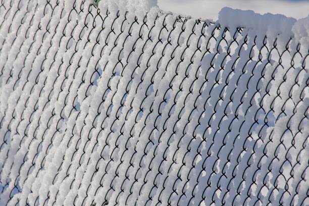 istock Snow and ice on chainlink fence 1445697920