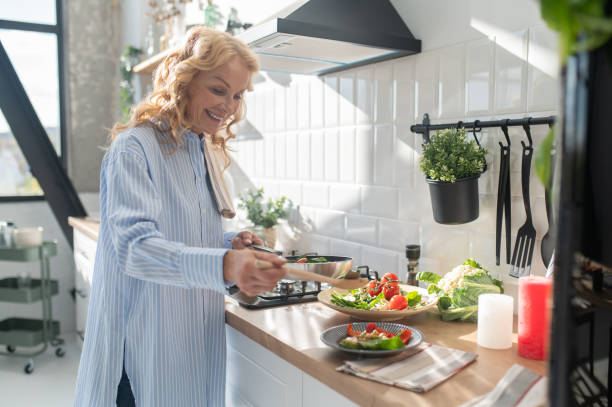 istock Blonde woman cooking and looking enjoyed 1445698253