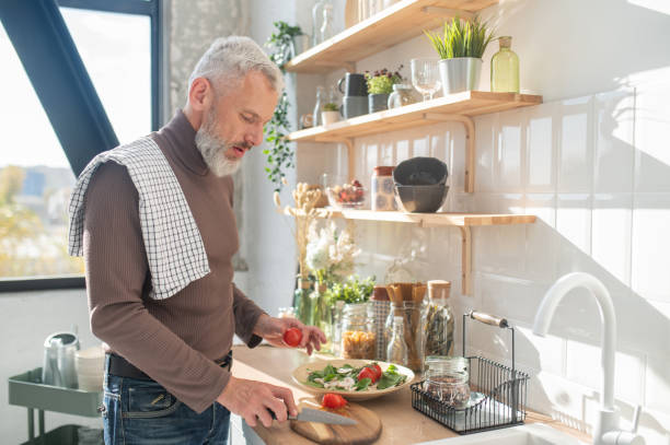 istock Gray-haired mature man cooking in the kitchen 1445698268