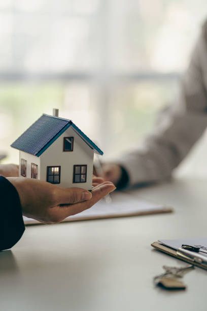 el concepto de comprar una casa, el agente ofrece contratos de tasa de interés en hipotecas y compras de viviendas para que los clientes firmen contratos con agentes inmobiliarios. - real estate agent fotografías e imágenes de stock