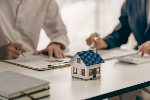 Concept of buying a house – agent offers mortgage and home purchase contracts for clients to sign – real estate lawyer – stock photo