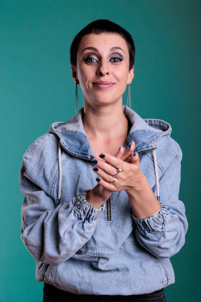 istock Smiling successful woman clapping hands and applauding achievement in studio 1445699650