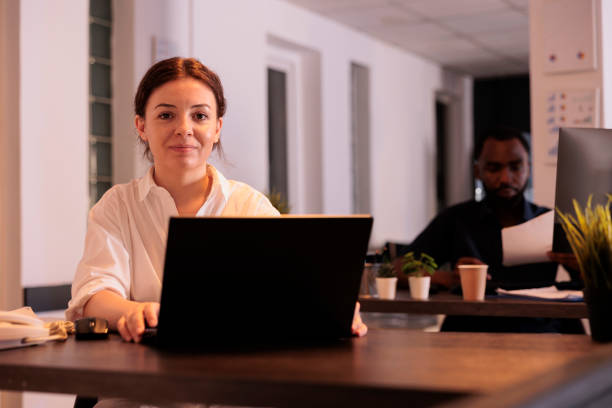 istock Smiling employee working on laptop in coworking space portrait 1445700429
