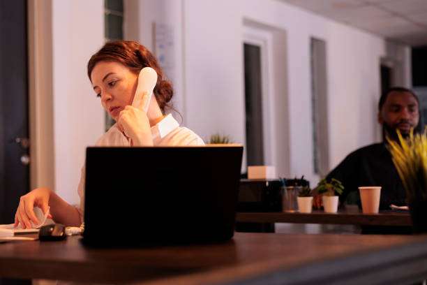 istock Secretary talking with client on landline phone, discussing report 1445700931