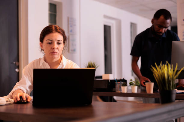 istock Tired corporate employee working on laptop in office late 1445701789