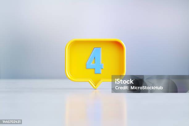 Yellow Speech Bubble Shape With Blue Number 4 Sitting Before Silver Defocused Background Stock Photo - Download Image Now