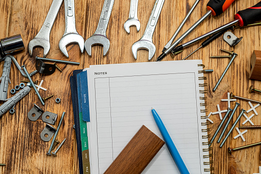 dowel screws and keys are scattered on the table next to a folder and a pen. repair concept.