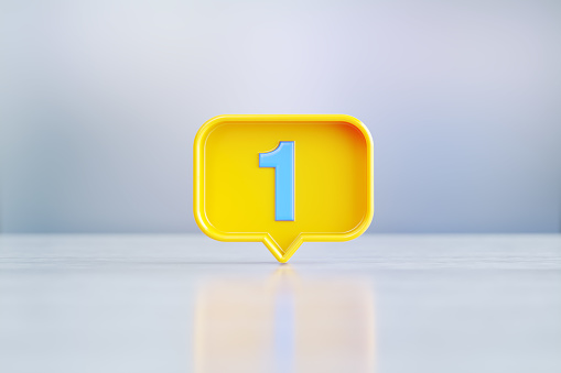 Yellow speech bubble with blue number 1 sitting on before silver defocused background. Horizontal composition with copy space.