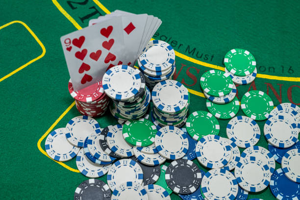 istock poker chips with playing cards on green casino table. 1445704323